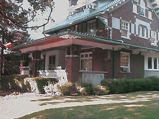 This 1914 Prairie style in Bloomington, IL features terra cotta tile fireplace, ornate beamed ceilings and an octagonal second floor foyer.