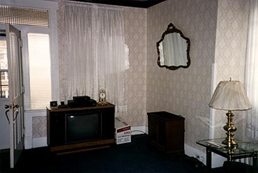 Rather than direct the furniture toward the fireplace - the focal point of the Craftsman home - the previous owner put their old console TV at the front of the house with the furniture angled toward it. Notice the front window covered by both a blind and curtain.